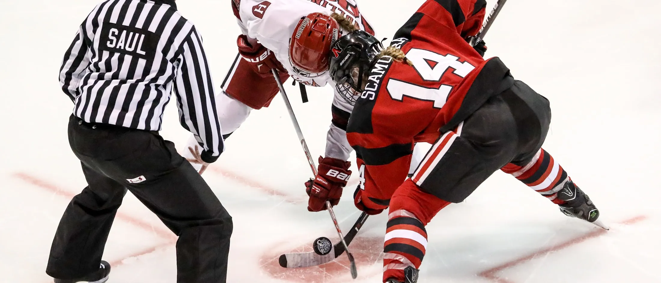 Two ice hockey players contesting the puck at a face-off